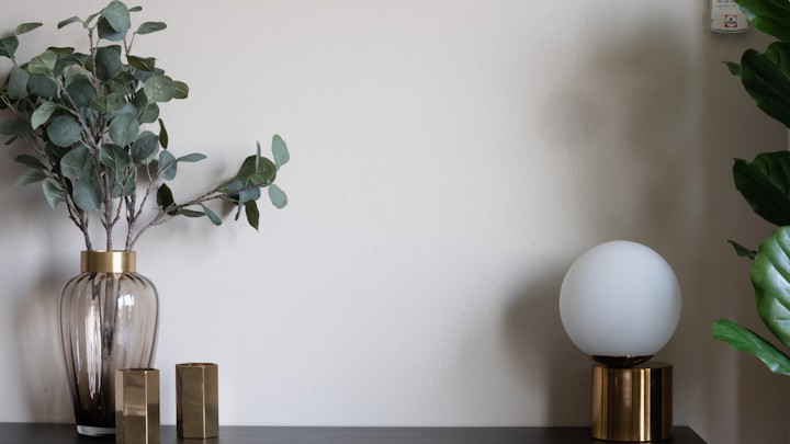 Konsole mit Eukalyptus in einer Vase und einer Kugelleuchte.