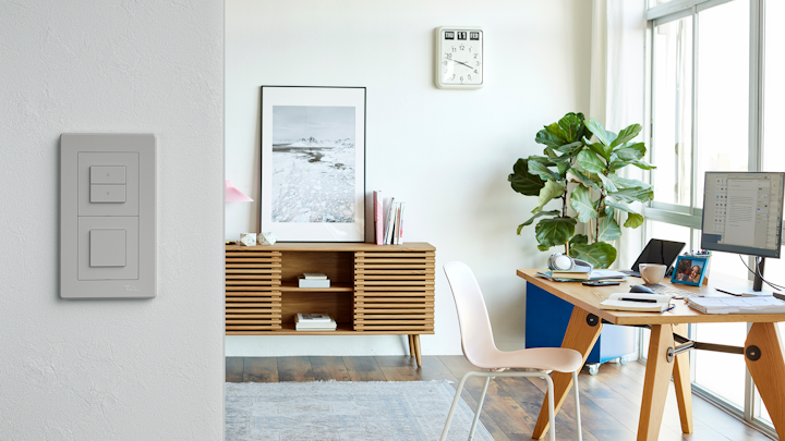 Arbeitszimmer mit Pflanze, Wanduhr und Wiser Schalter im Design EDIZIO.liv, hellgrau.