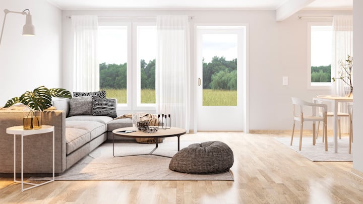 Wohnzimmer mit Sofa und dunklem kleinen Tisch. Lichtdurchflutet.